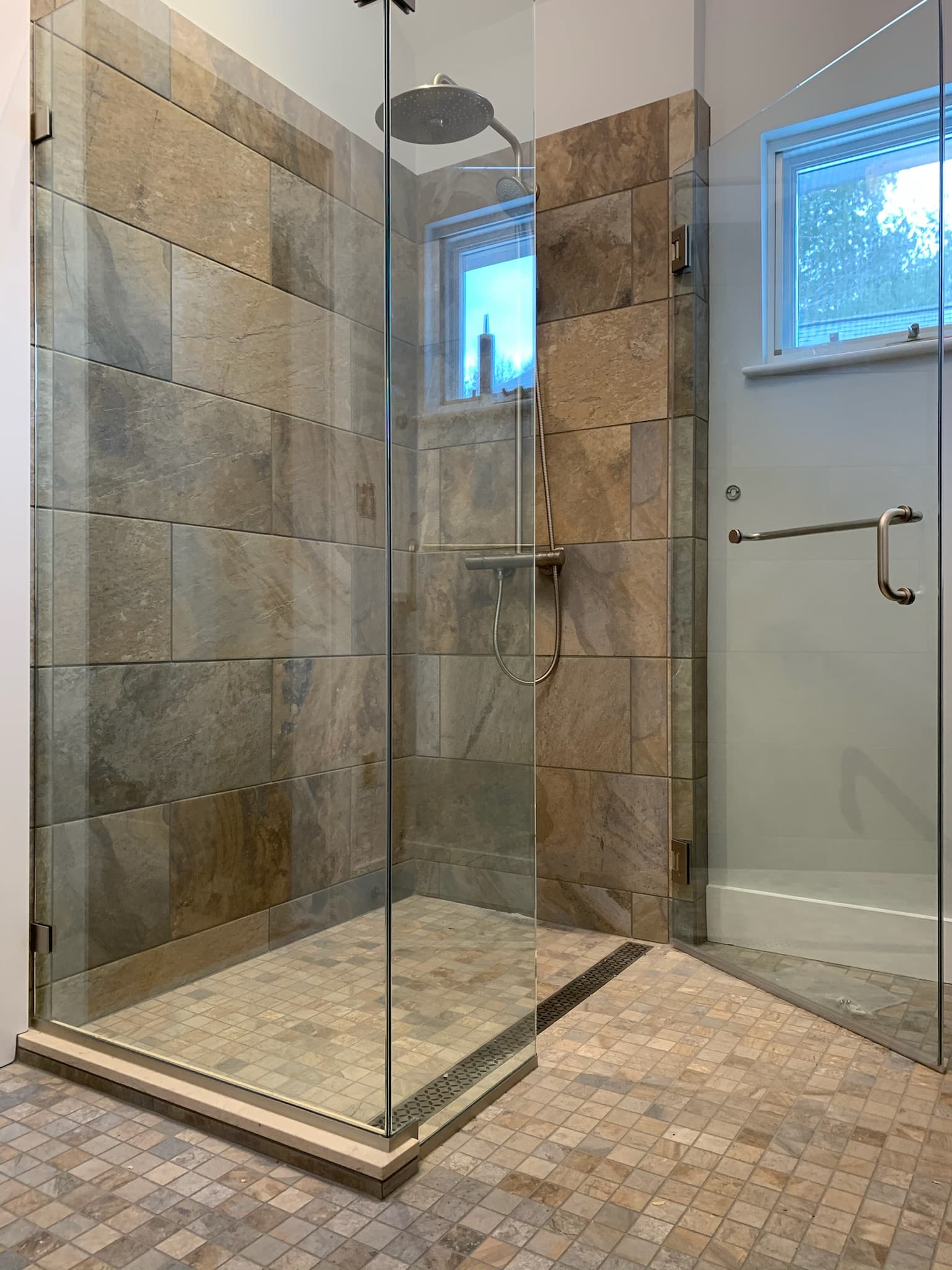 continuos bathroom tile floor into shower with glass door